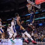 New Orleans Pelicans guard CJ McCollum (3) throws an alley-oop pass to forward Zion Williamson (1) for the dunk against Philadelphia 76ers forward Tobias Harris (12) during the second half at the Smoothie King Center.
